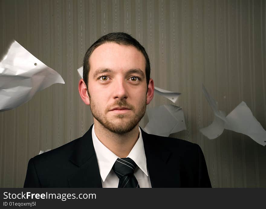 Young business man with paper blowing behind. Young business man with paper blowing behind