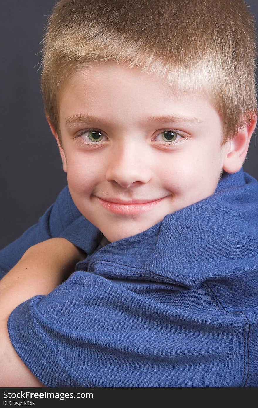 Friendly boy with a blue shirt against a black background