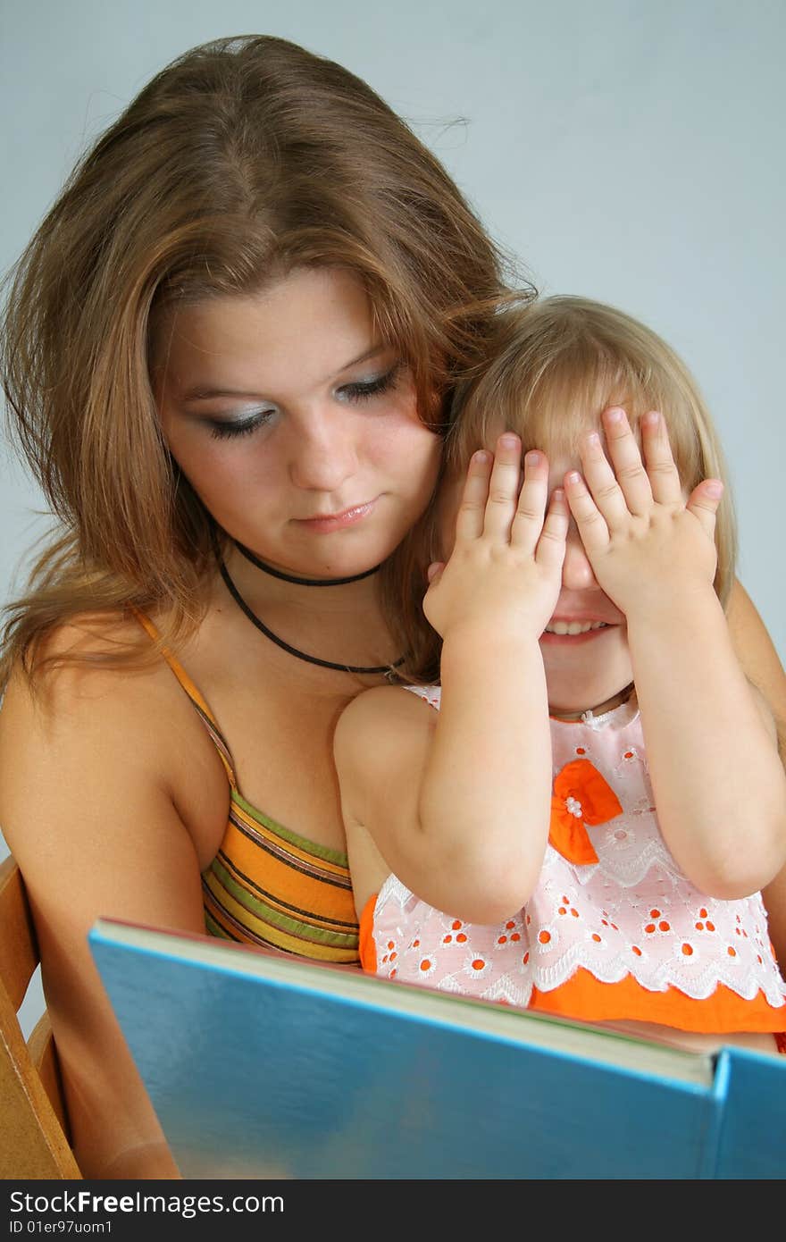 Two sisters different ages read the large book