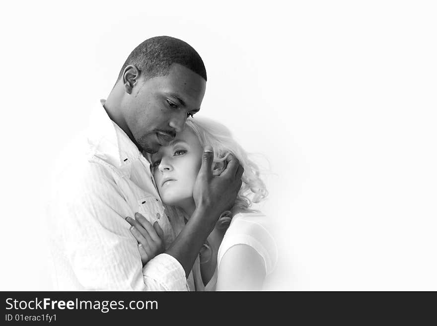 African American man and Caucasian woman holding each other. Naturally lit, high-key image on white background. African American man and Caucasian woman holding each other. Naturally lit, high-key image on white background.