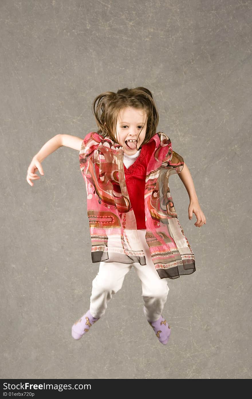 Little girl leaping into the air, over gray background. Little girl leaping into the air, over gray background