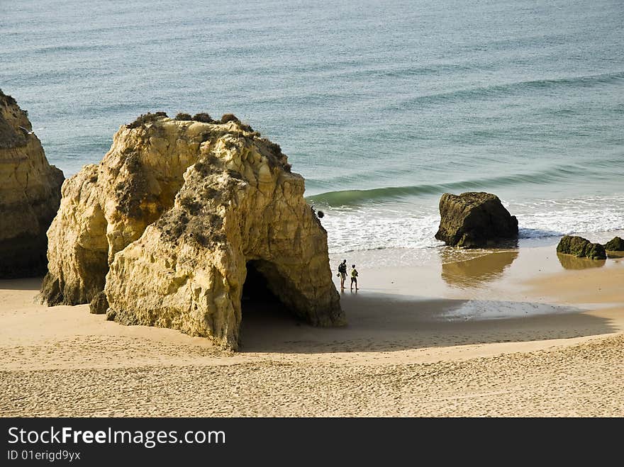 2 tourists walk in Praia da Rocha, Portimao, Algarve