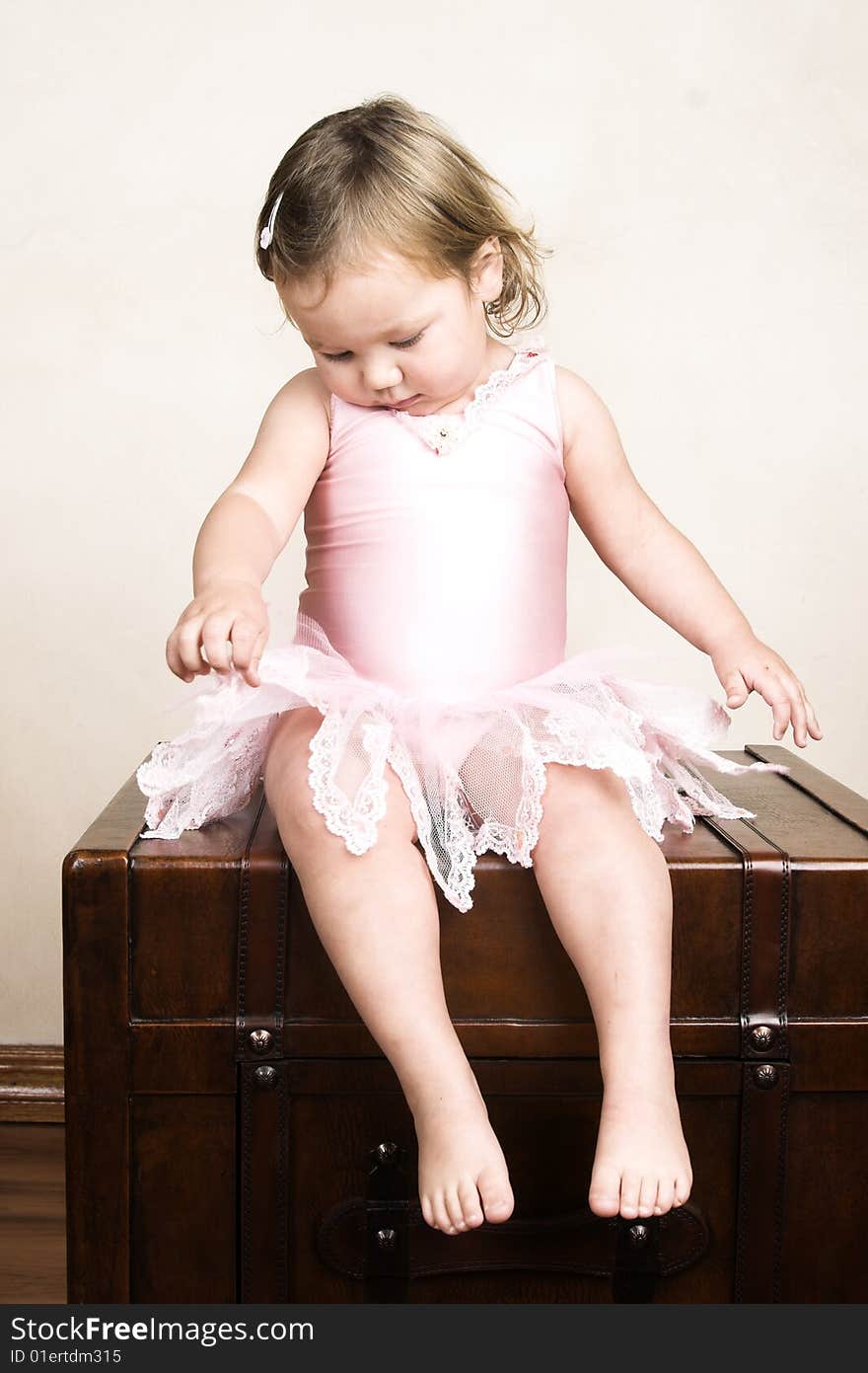 Little girl with short hair wearing a pink ballet outfit