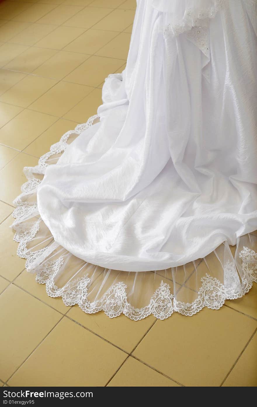 Loop of a wedding dress on a floor.