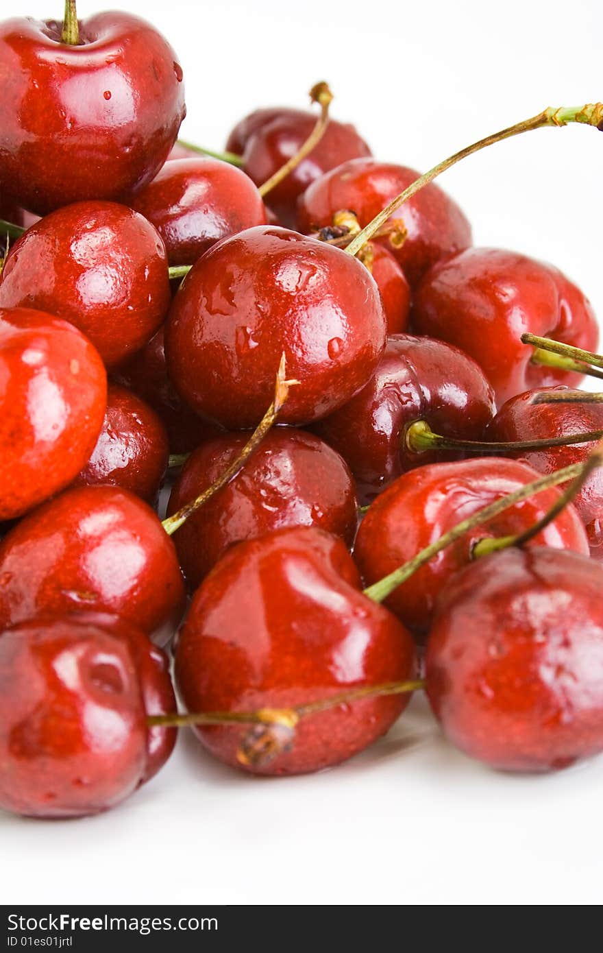 A pile of fresh cherries with stems on white. A pile of fresh cherries with stems on white