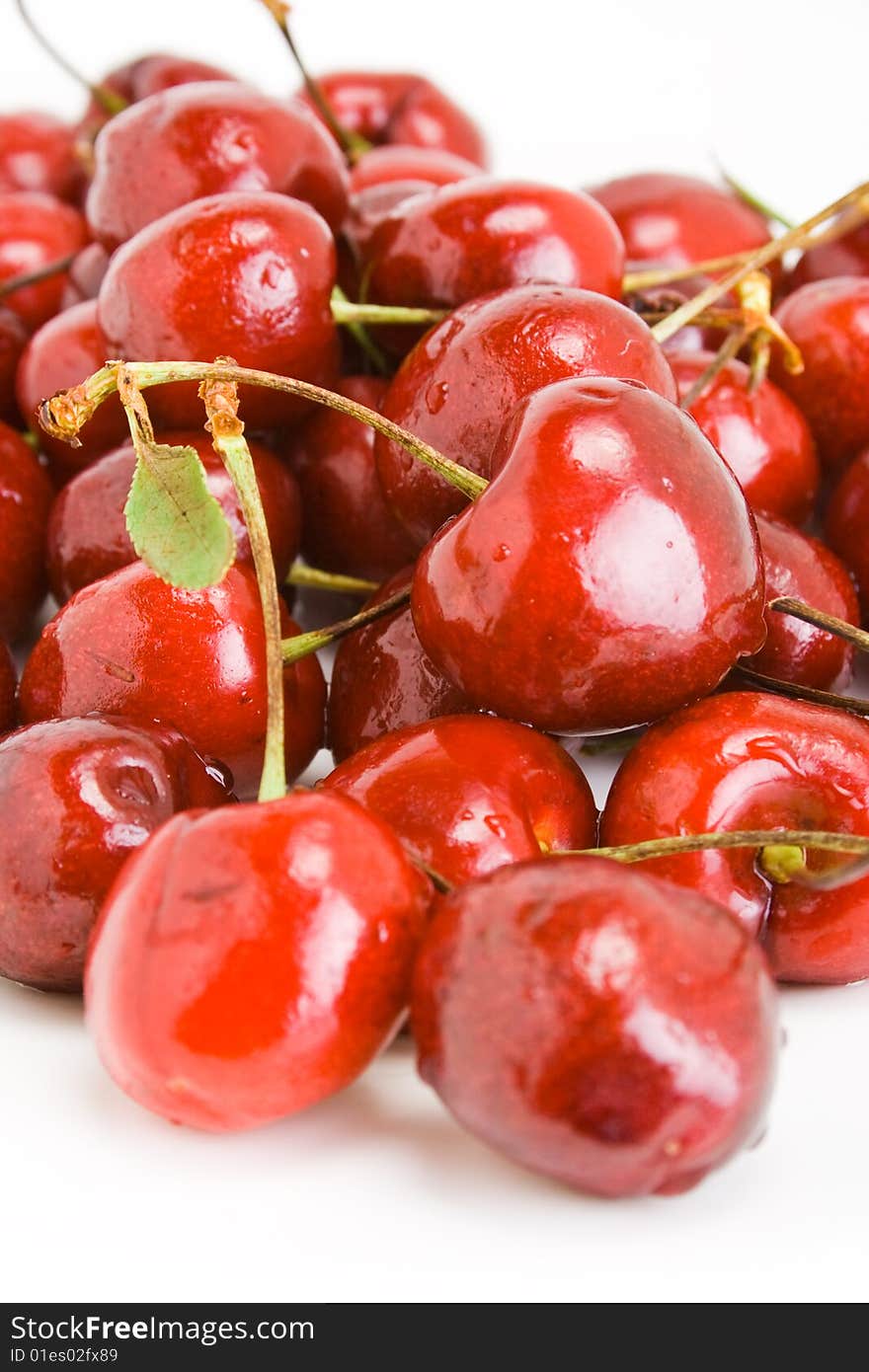 A pile of fresh cherries with stems on white. A pile of fresh cherries with stems on white