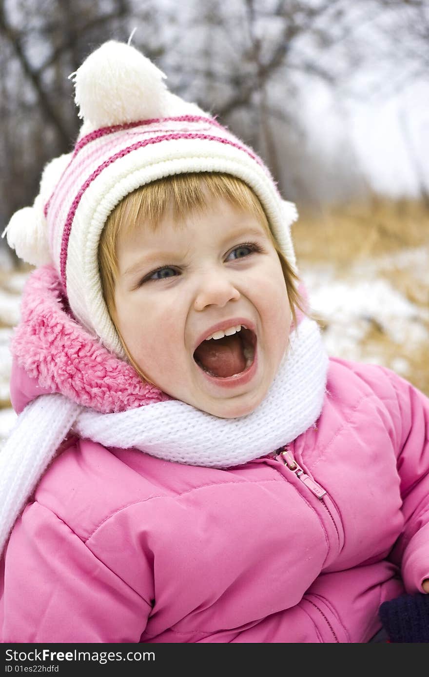 �ryrying baby in pink jacket on the winter background