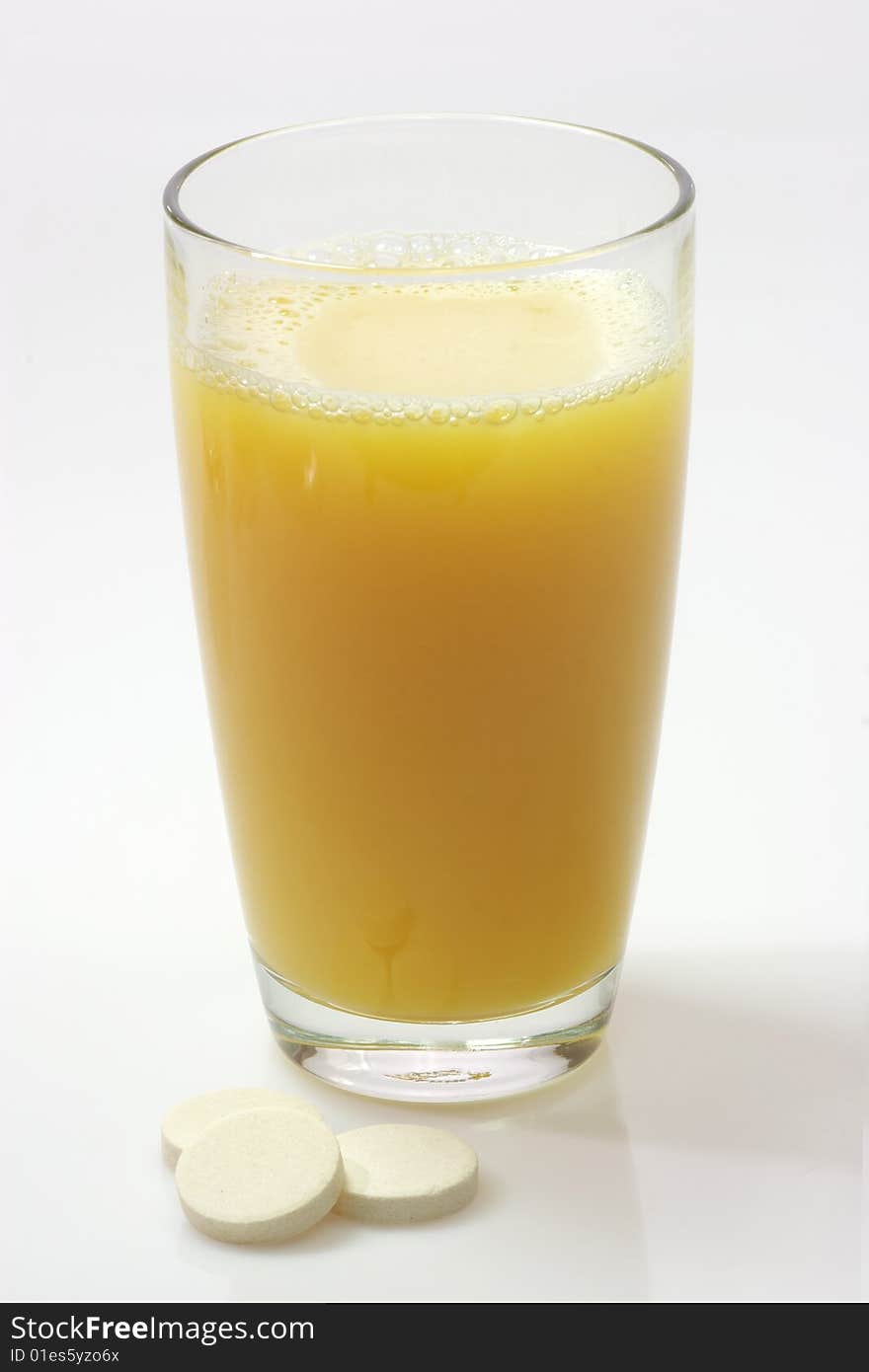 Glas of fizzy liquid with Effervescent tablets on bright background. Glas of fizzy liquid with Effervescent tablets on bright background