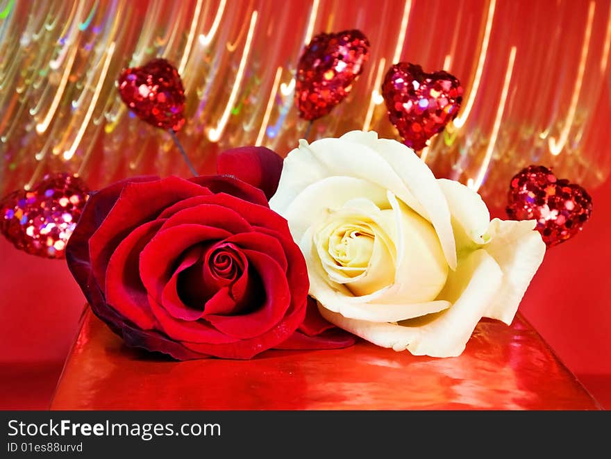 Celebrating love - white and red roses with sparkling hearts over blurred show of lights. Celebrating love - white and red roses with sparkling hearts over blurred show of lights.