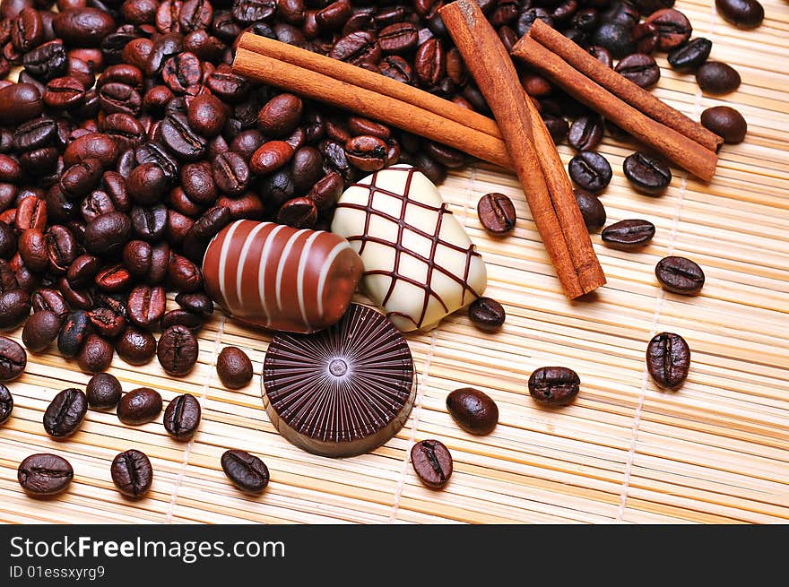 Chocolates with cinnamon on a stack of coffee beans background