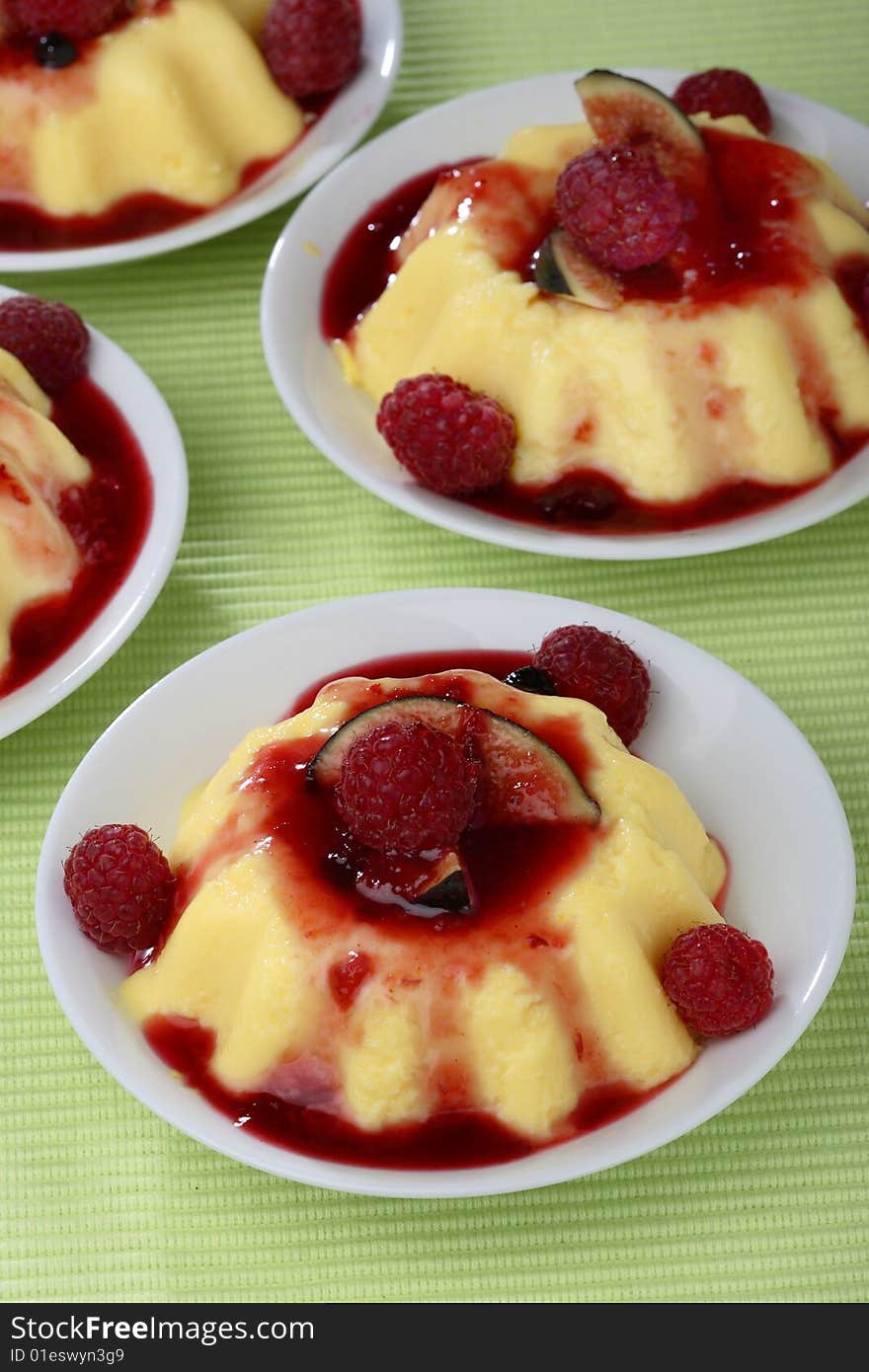 Panacota with fresh raspberries in bowls on table