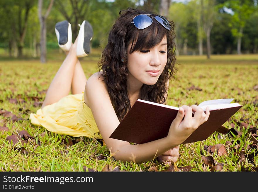 Girl reading book in the outdoors