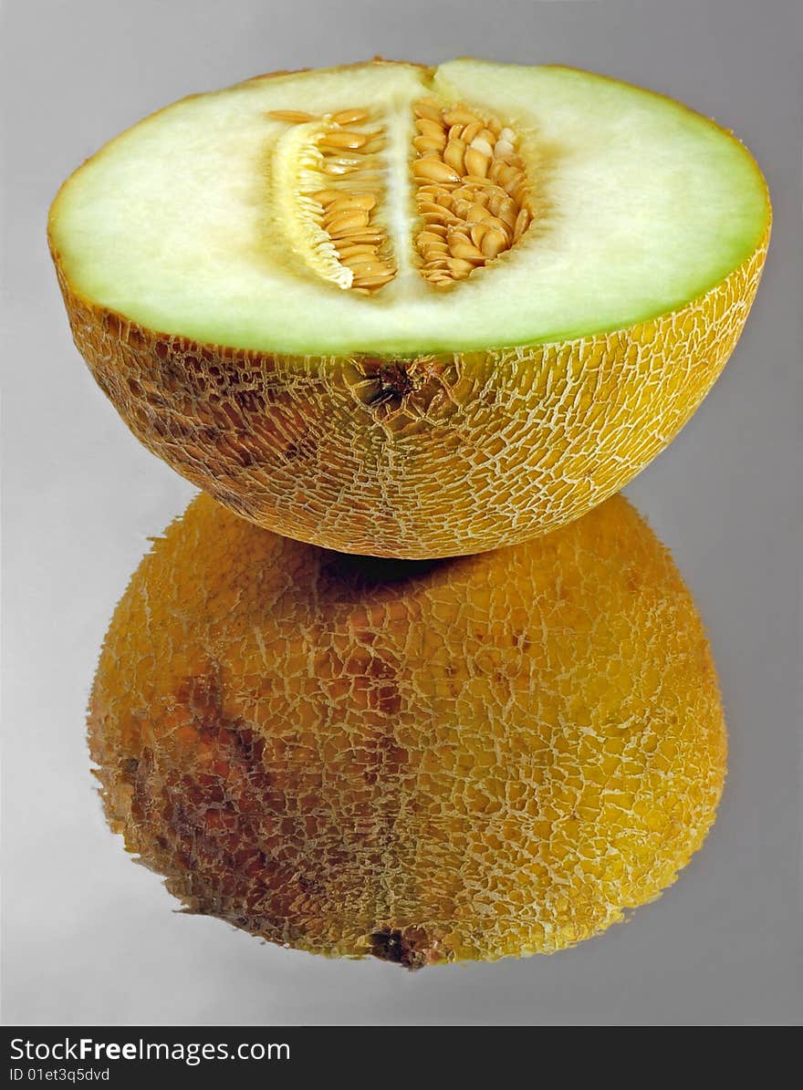 Half of melon on a mirror surface. Half of melon on a mirror surface.