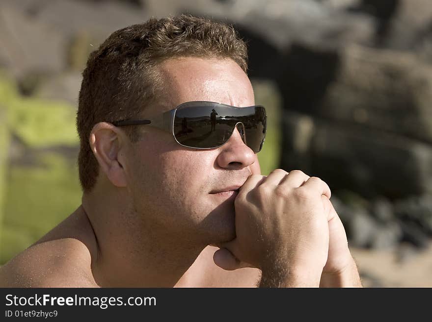 Portrait of a young mediterranean man seated in at beach