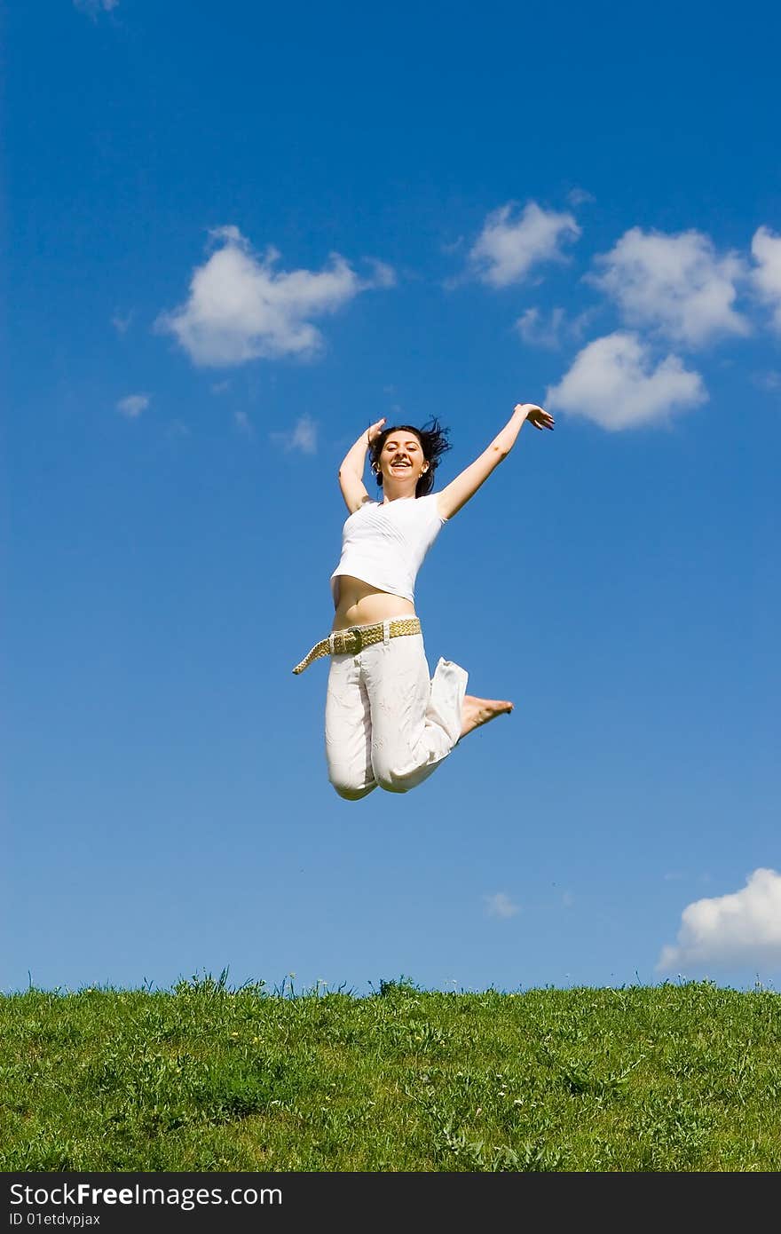 Happy young woman is jumping in green grass. Happy young woman is jumping in green grass