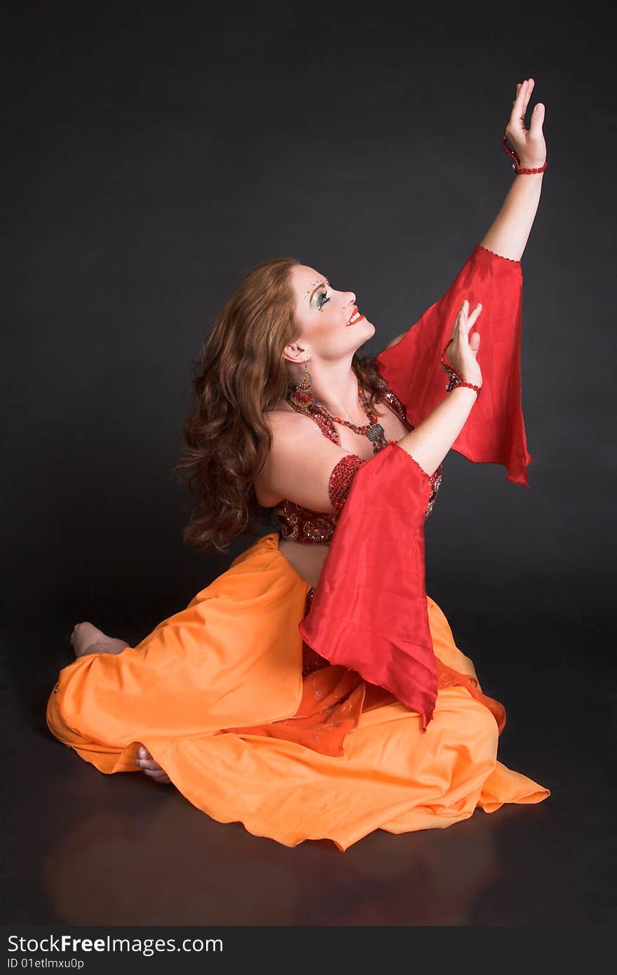 Belly Dancer wearing a red costume with jewelery. Belly Dancer wearing a red costume with jewelery