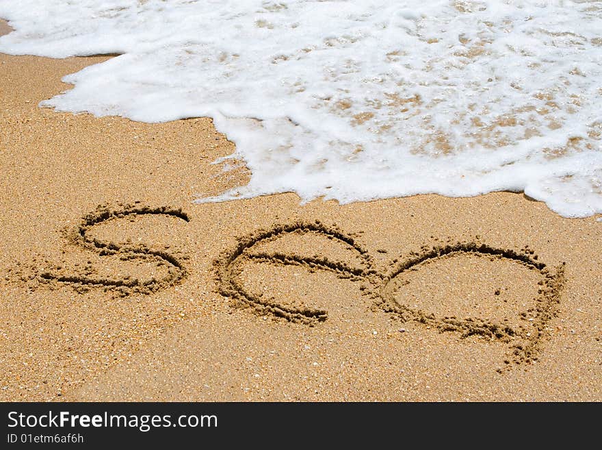 sea written in the sandy beach