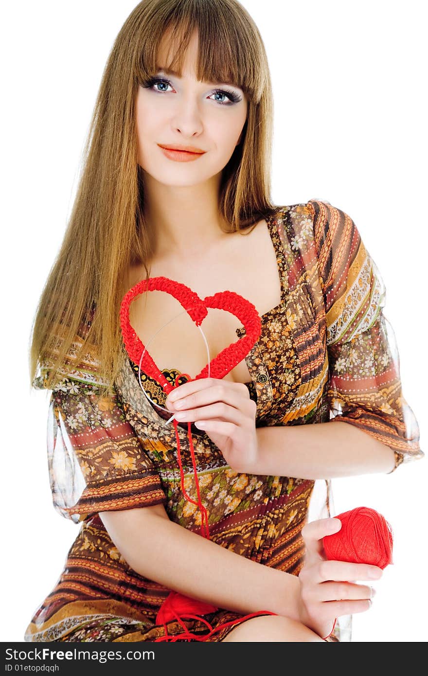 Young blond holding a red knit heart. Young blond holding a red knit heart