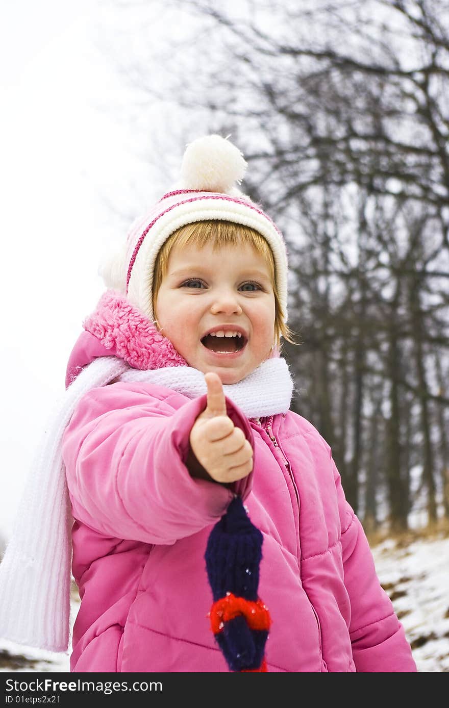 Smiling baby in pink jacket on the winter background