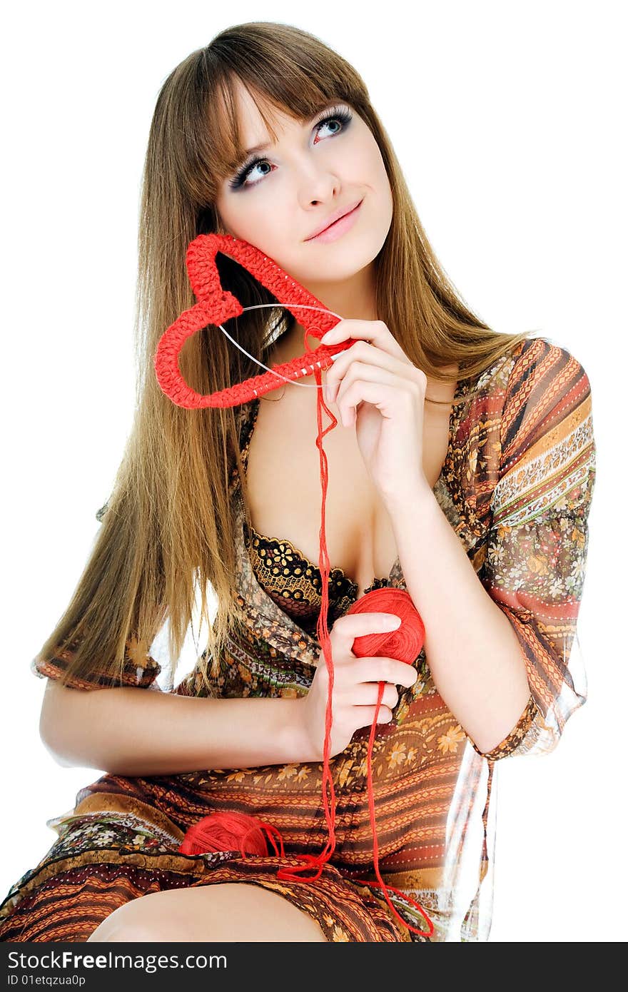 Young blond holding a red knit heart. Young blond holding a red knit heart