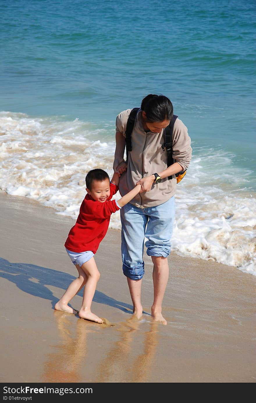 Father and son playing in the surfy beach