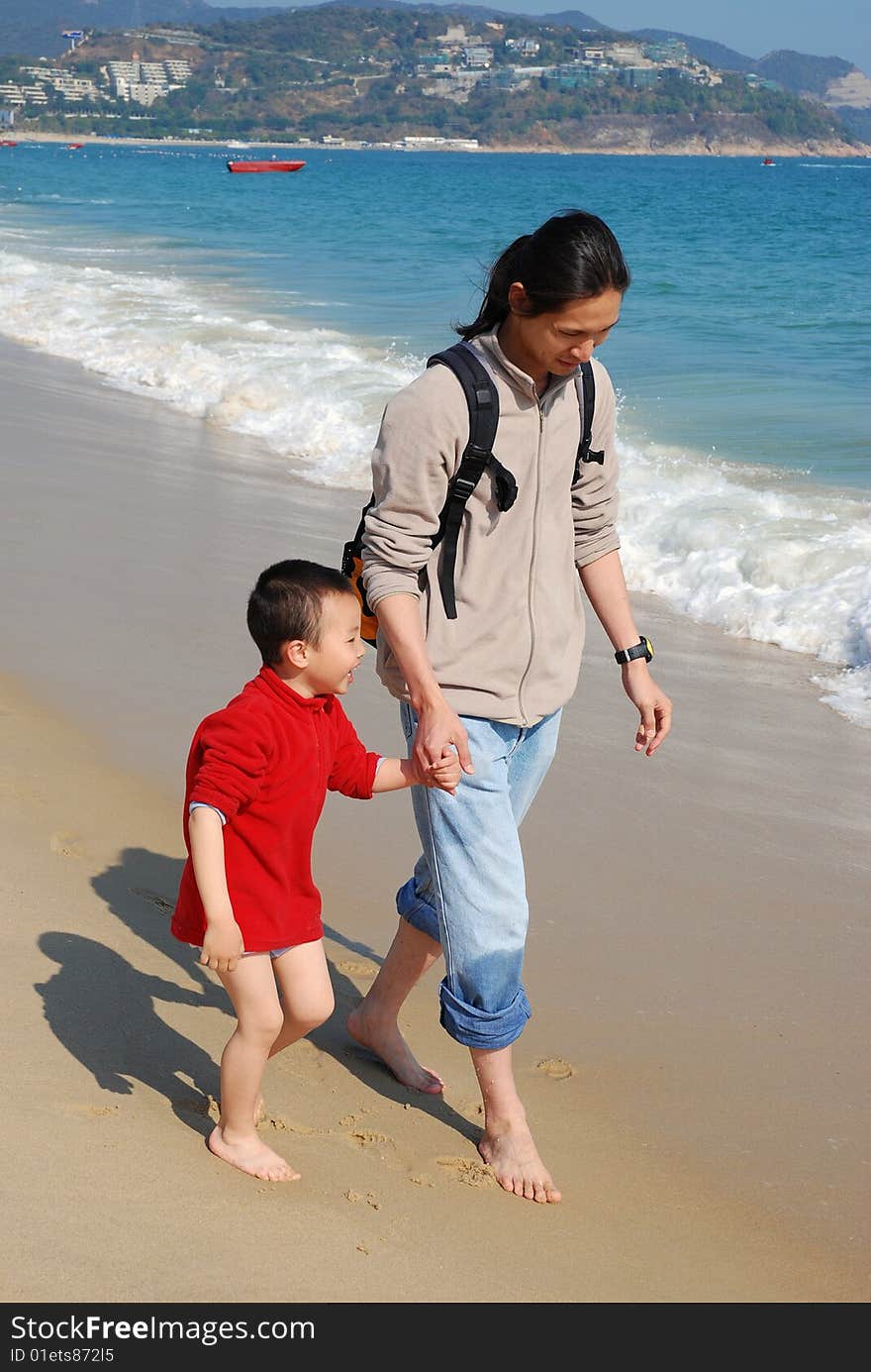 Father and Son Walking in the surfy beach