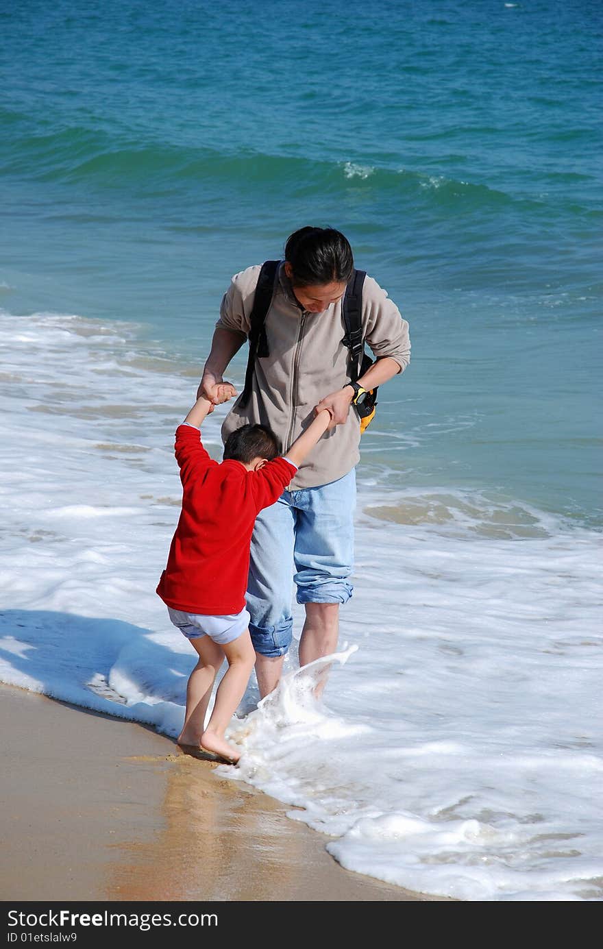 Father and son playing in the surfy beach