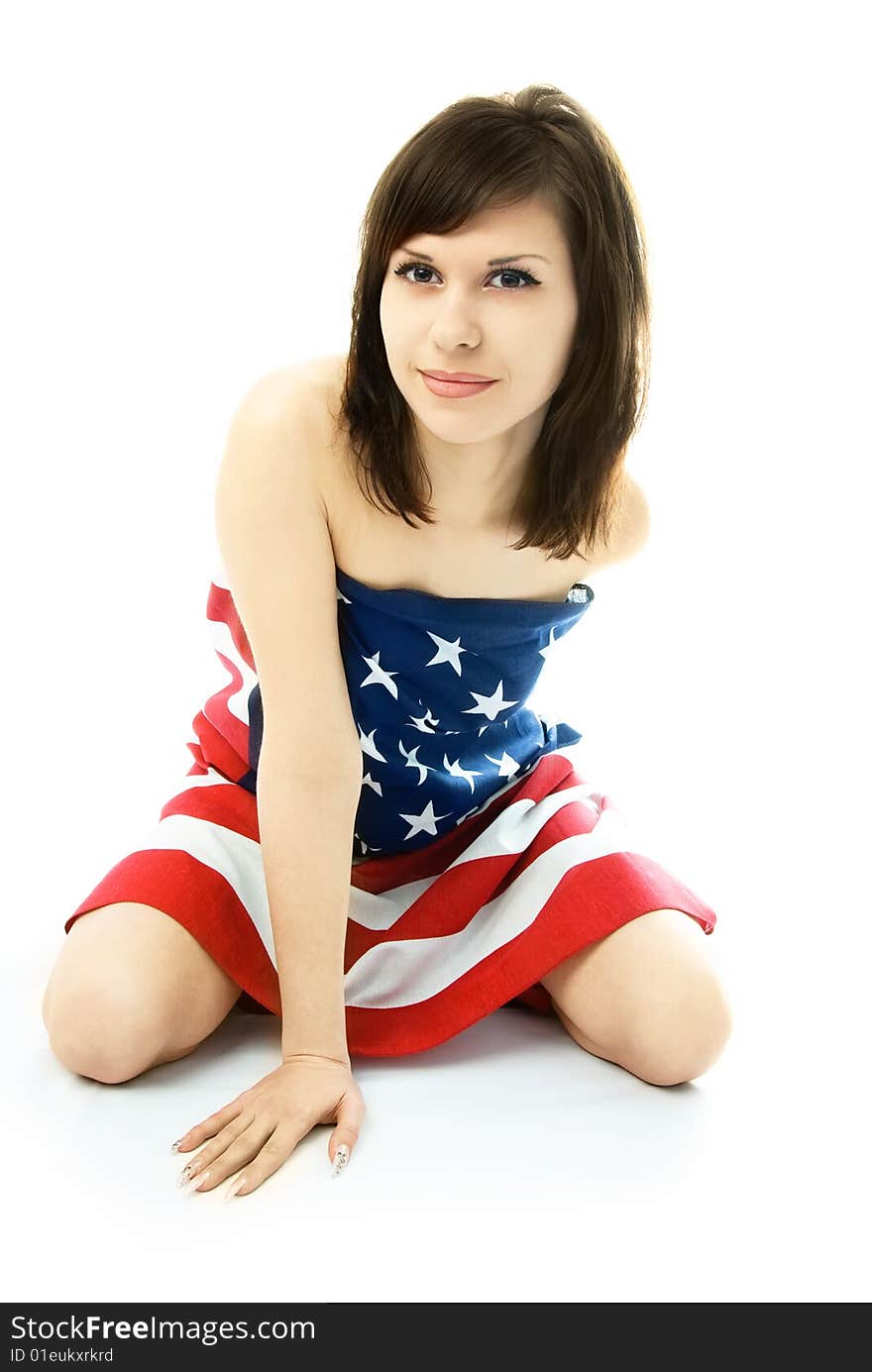 young woman wrapped into the American flag sits on the floor. young woman wrapped into the American flag sits on the floor