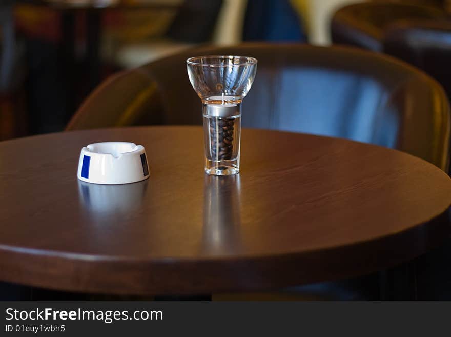 Ashtray and a glass full of coffee beans. Ashtray and a glass full of coffee beans