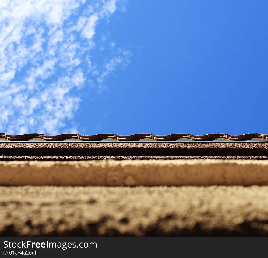 A textured photo of a wall and sky with lines of material in the foreground and sky and clouds in the background. A textured photo of a wall and sky with lines of material in the foreground and sky and clouds in the background