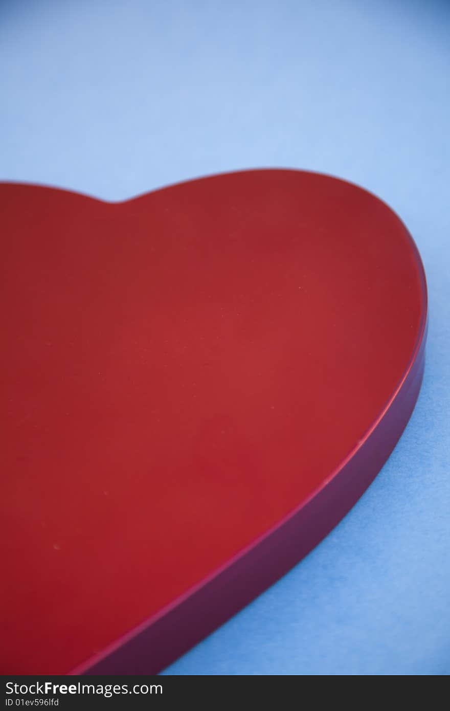 A close-up of a red heart shaped symbol on a blue background. A close-up of a red heart shaped symbol on a blue background