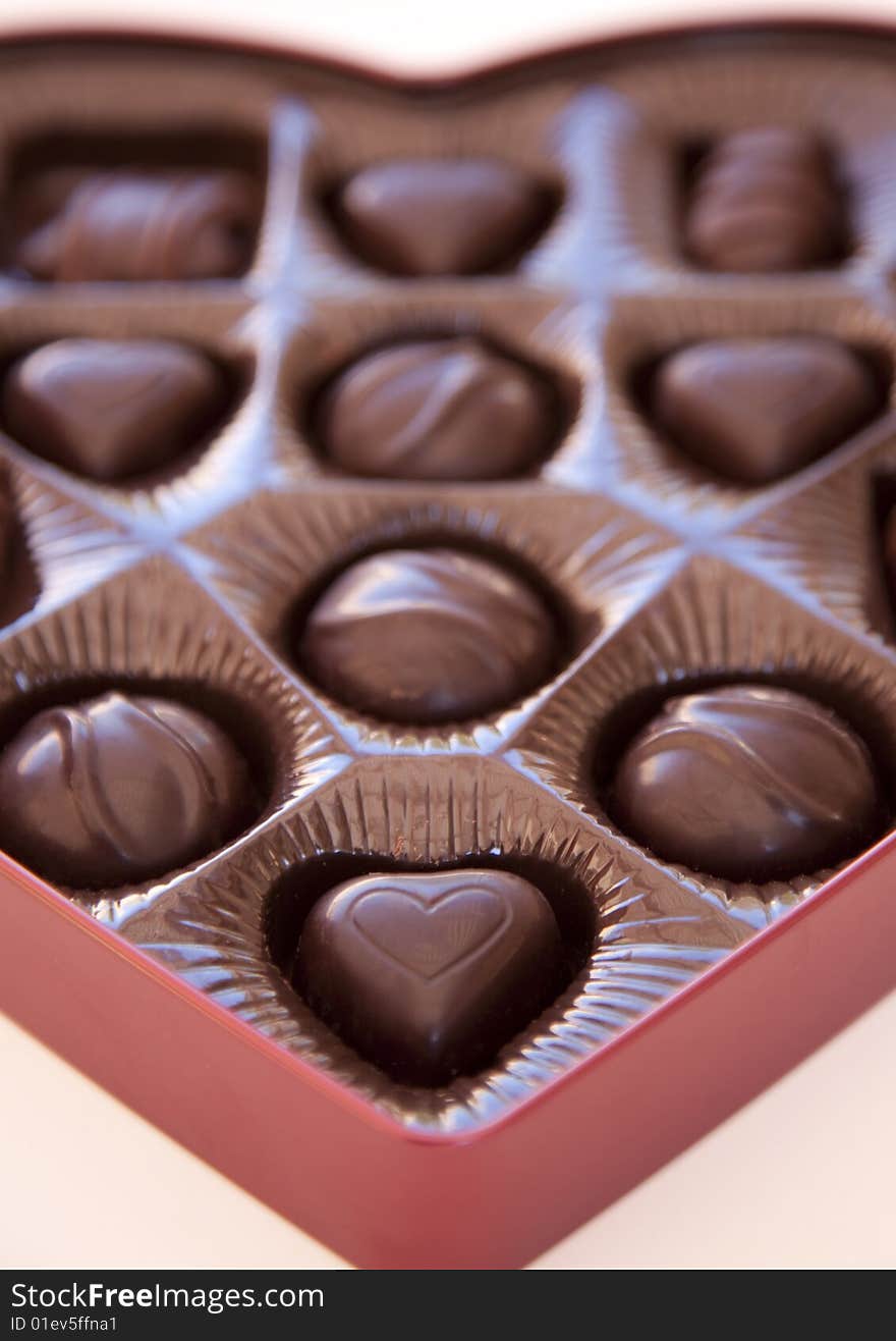 A close-up shot of valentine's day chocolates with the focus on the foreground of a heart shaped chocolate. A close-up shot of valentine's day chocolates with the focus on the foreground of a heart shaped chocolate