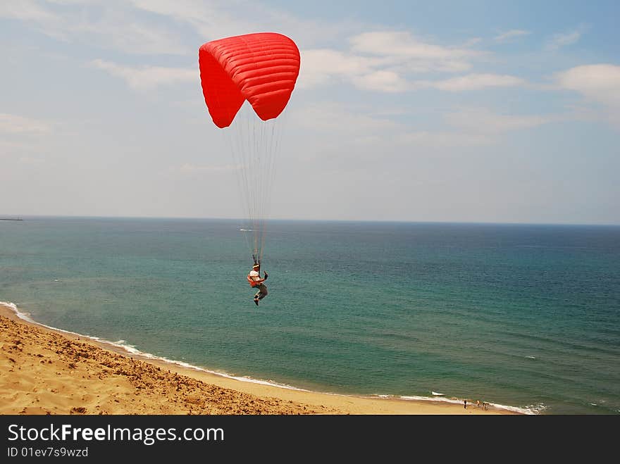 Man flying on a parachute in a desert