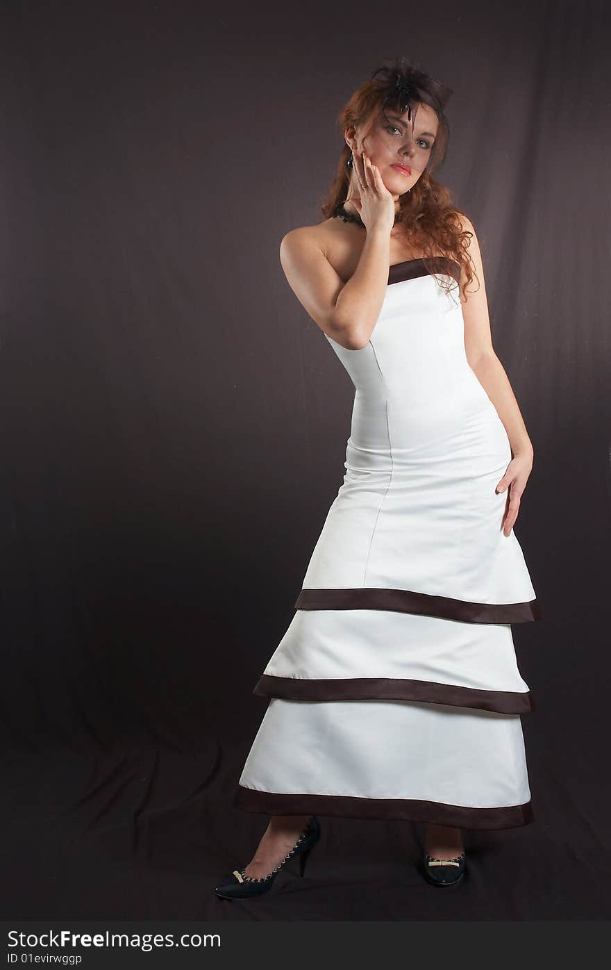 The young beautiful girl in a white smart evening dress. The young beautiful girl in a white smart evening dress