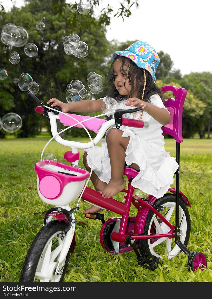 Asian girl in the garden riding her cycle