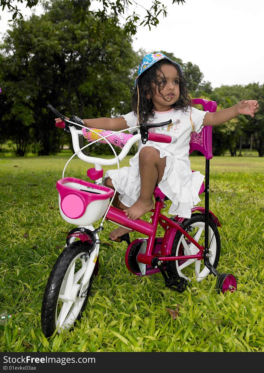 Asian girl in the garden riding her cycle