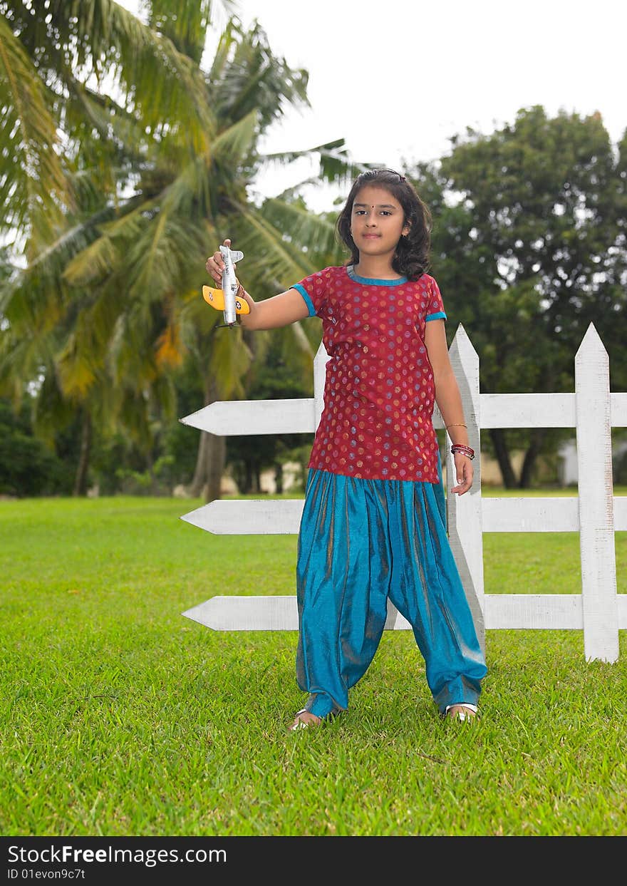 Asian kid in the park with her toy aeroplane