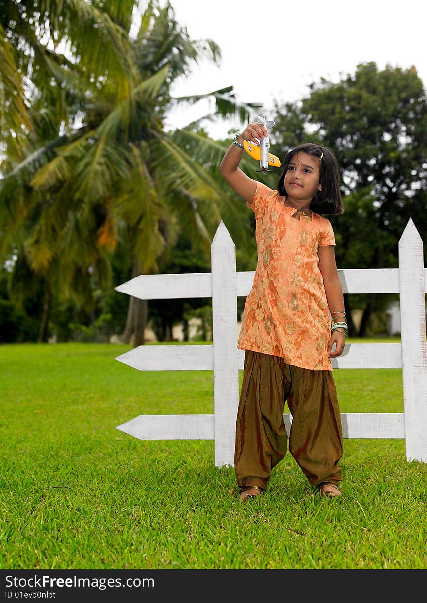 Kid in the park with her toy aeroplane