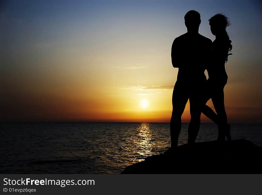 Silhouette of in love couple  on a background sea sunset