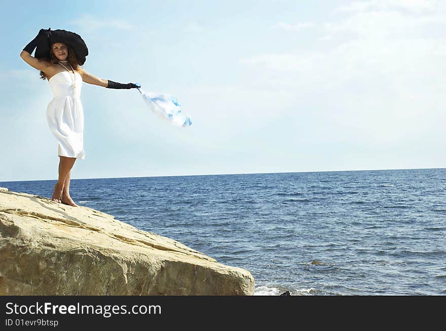 girl in a black hat holds headscarf on a wind