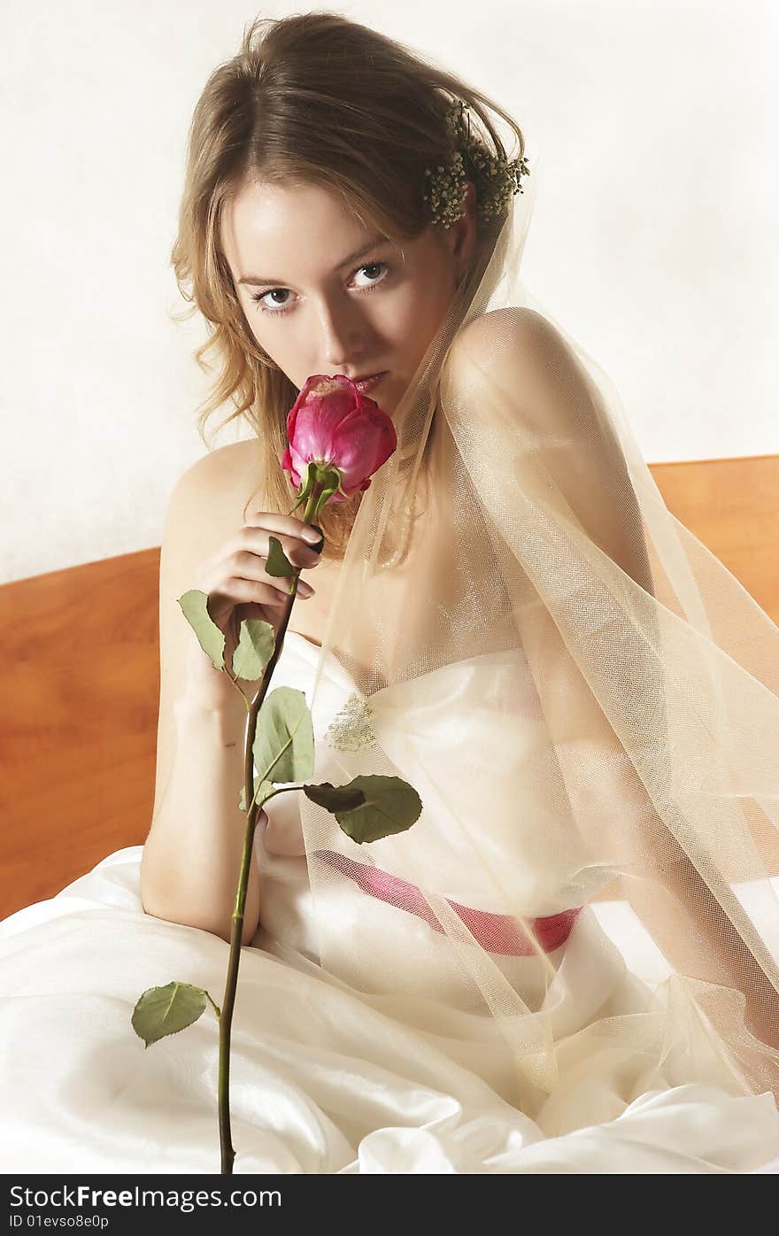 Beautiful bride sits with a red rose. Beautiful bride sits with a red rose