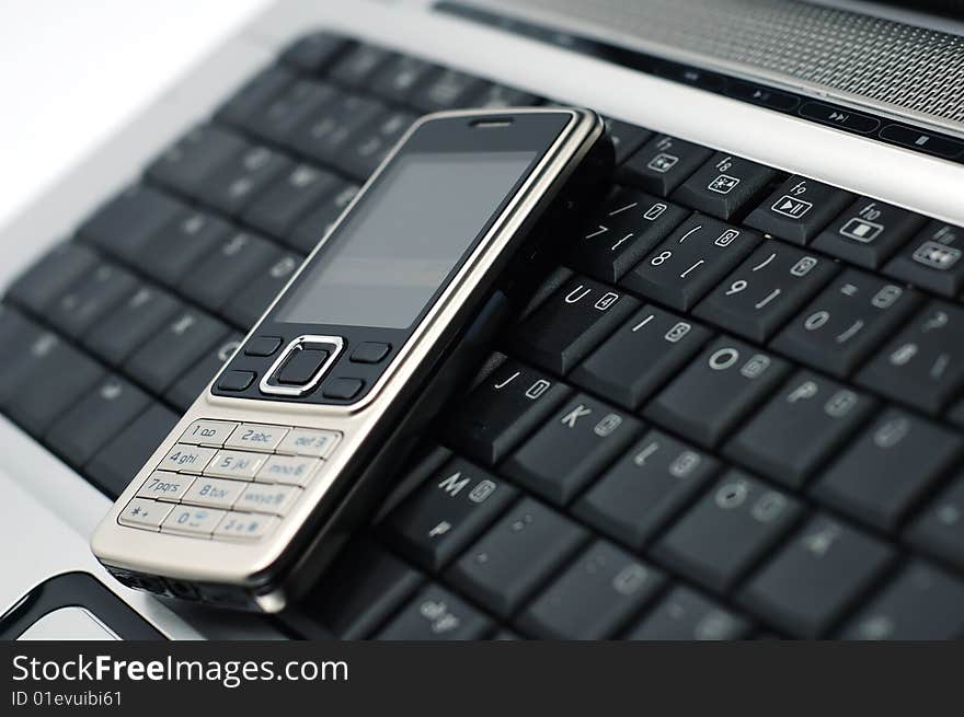 Mobile phone on a laptop with white background