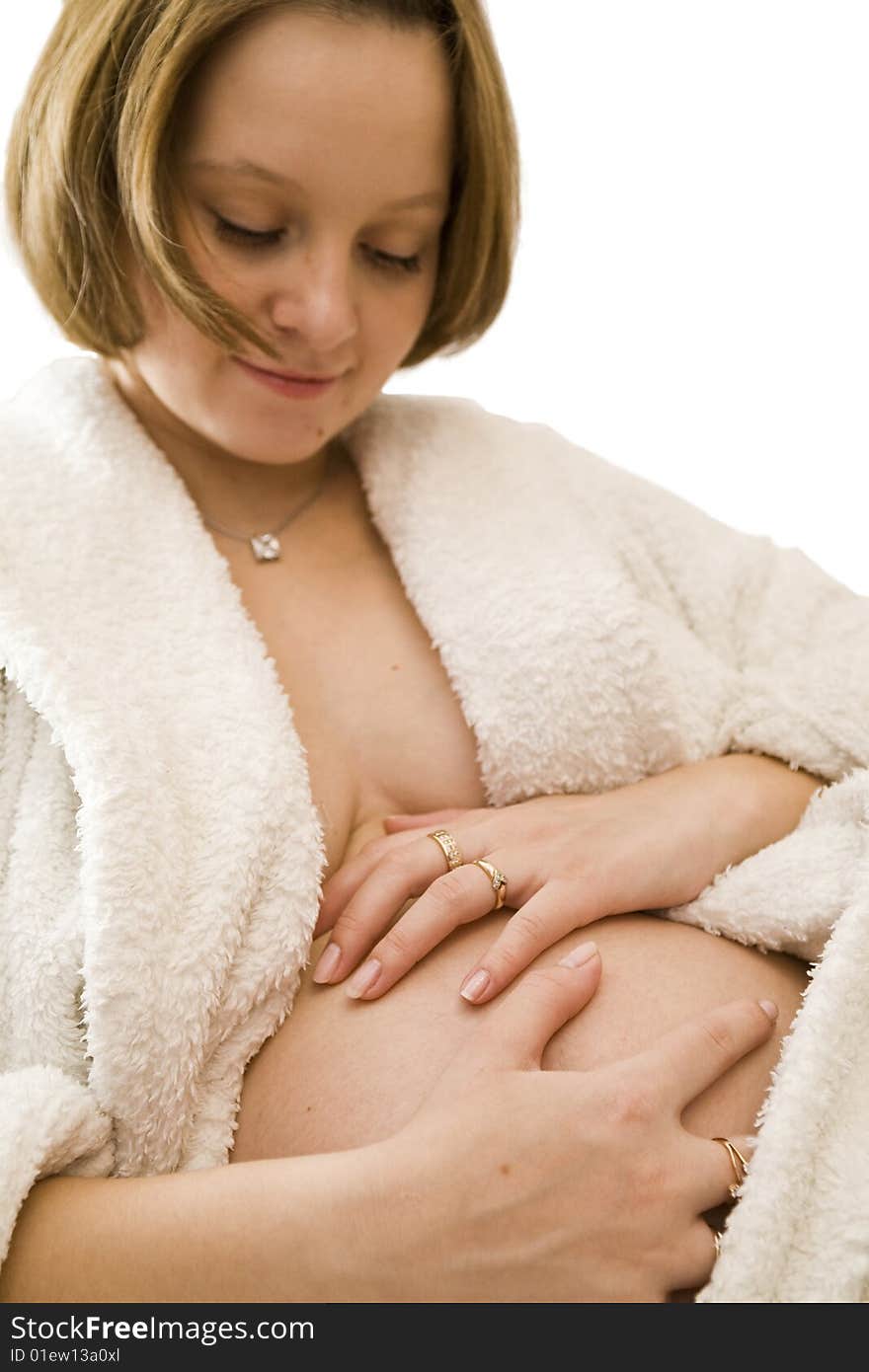 Pregnant woman holding her belly in white dress