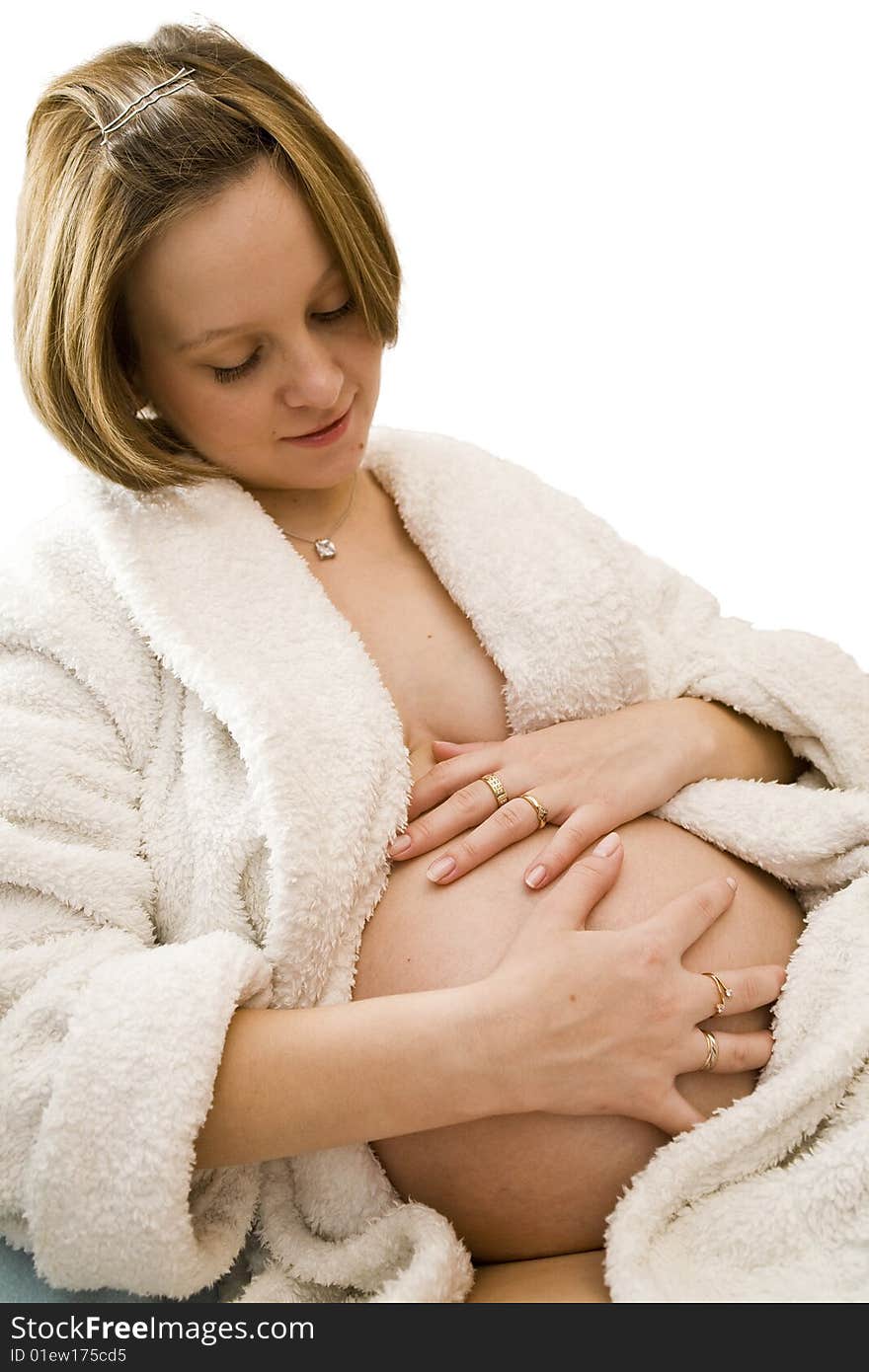 Pregnant woman holding her belly in white dress