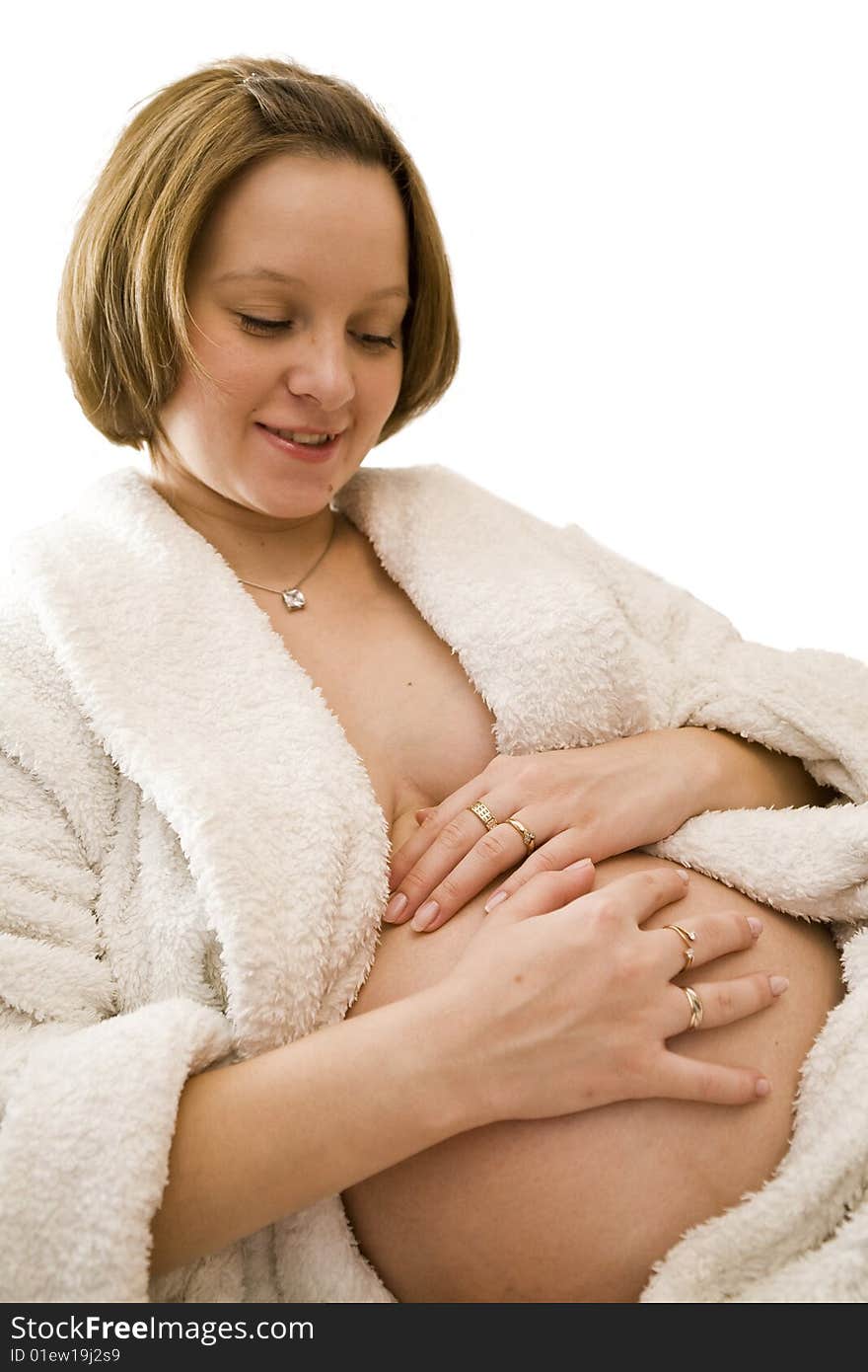 Pregnant woman holding her belly in white dress