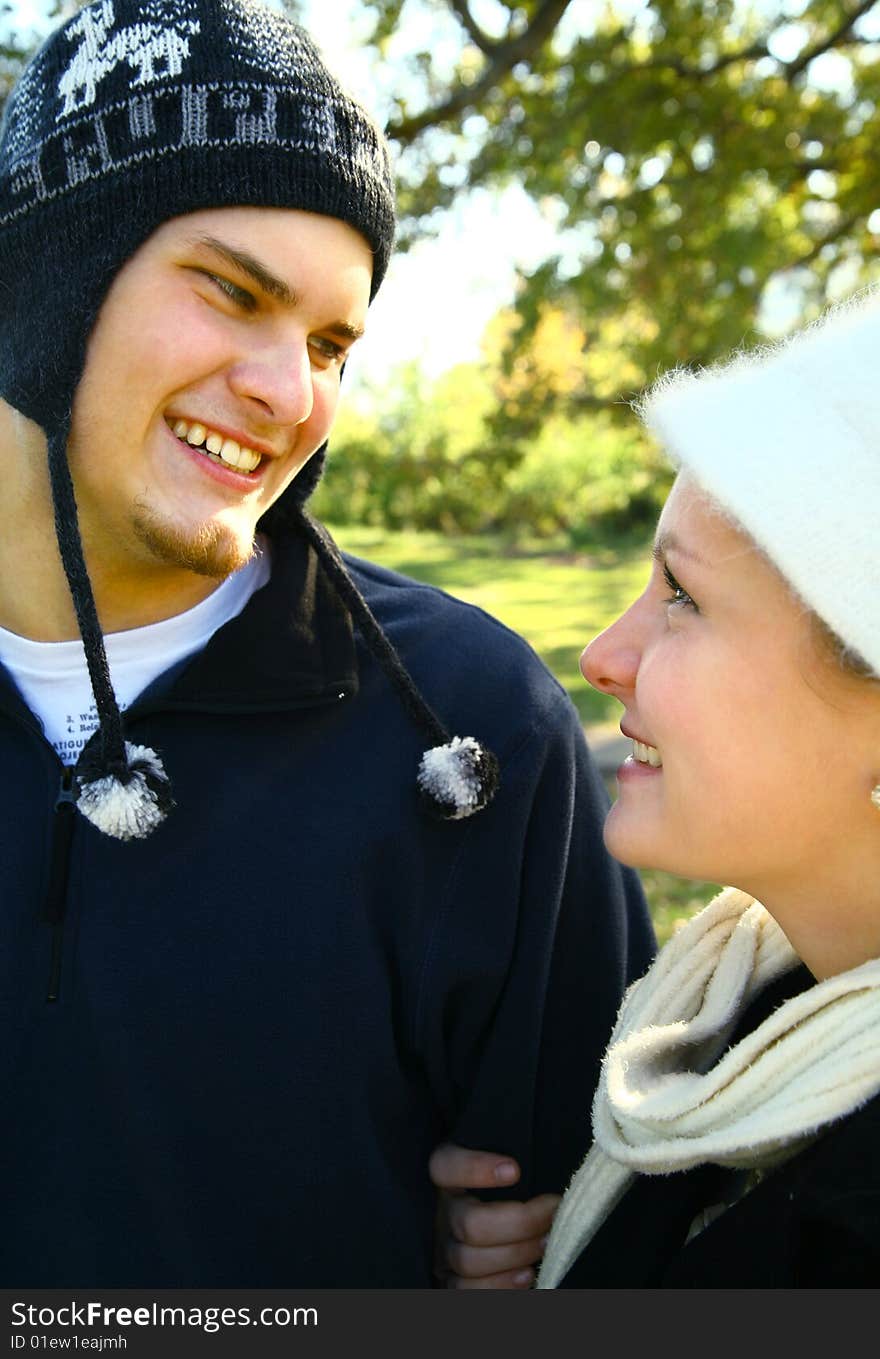 Two nice romantic young caucasian couple in urban style walking in the park. Two nice romantic young caucasian couple in urban style walking in the park