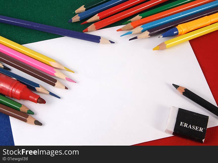 Background with a leaf of white paper and color pencils. Background with a leaf of white paper and color pencils.