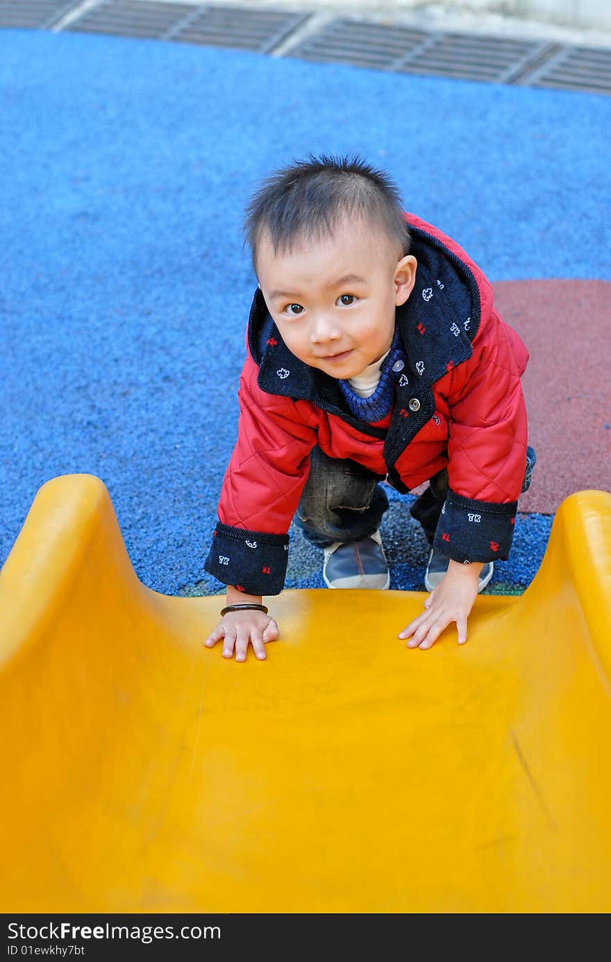 The asian boy playing the sliding board