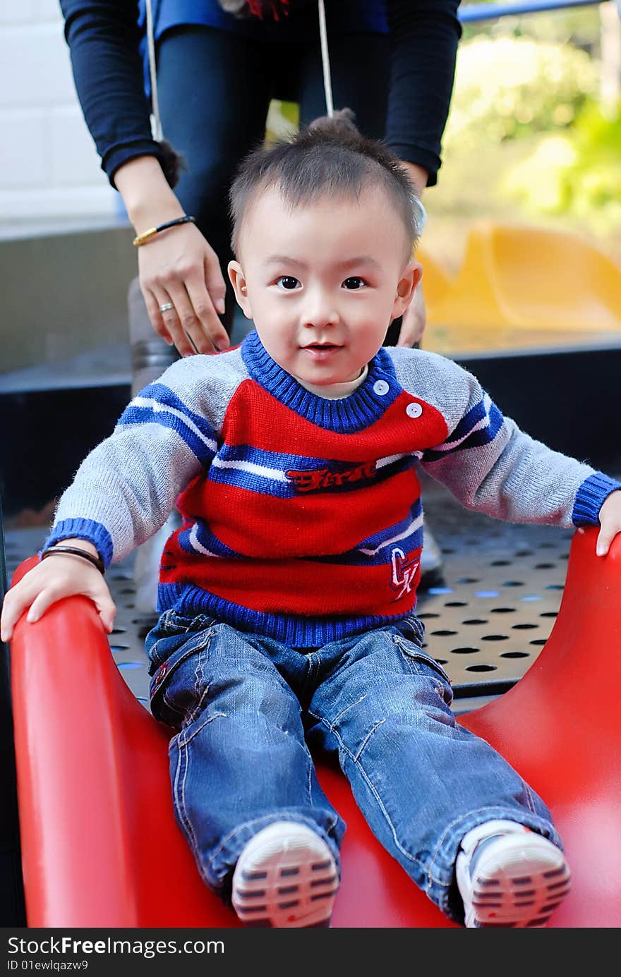 The asian boy playing the sliding board