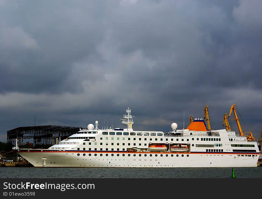 White beauty cruiser on dark sky at pier in the Lithuanian Port of Klaipeda. White beauty cruiser on dark sky at pier in the Lithuanian Port of Klaipeda.